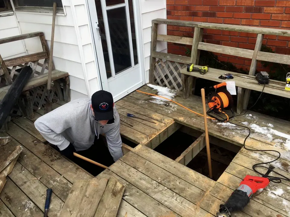 Dustin working through an opening cut in a backyard deck