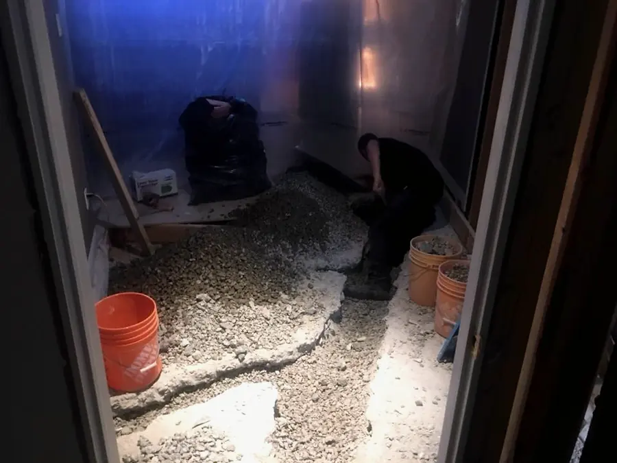 Dustin digging out under a basement floor